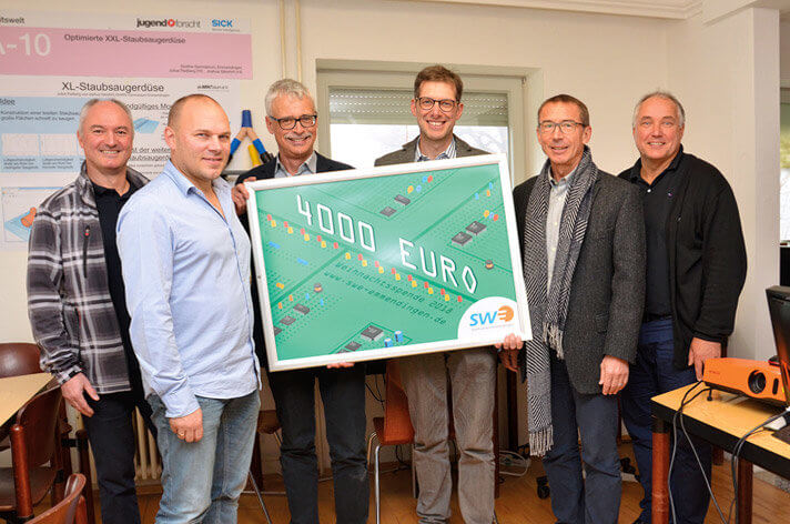 Karl-Heinrich Jung übergibt die Weihnachtsspende an das aluMINTzium-Team.