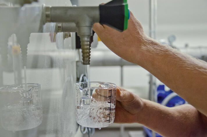 Entnahme einer Wasserprobe an einem Wasserhahn im Wasserwerk